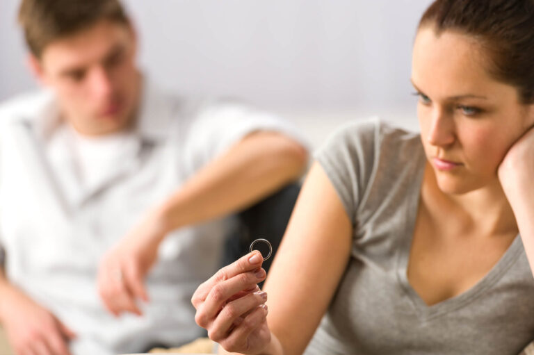 ייזום הליך גירושין | אישה מסתכלת על הטבעת נישואין שלה עצובה
