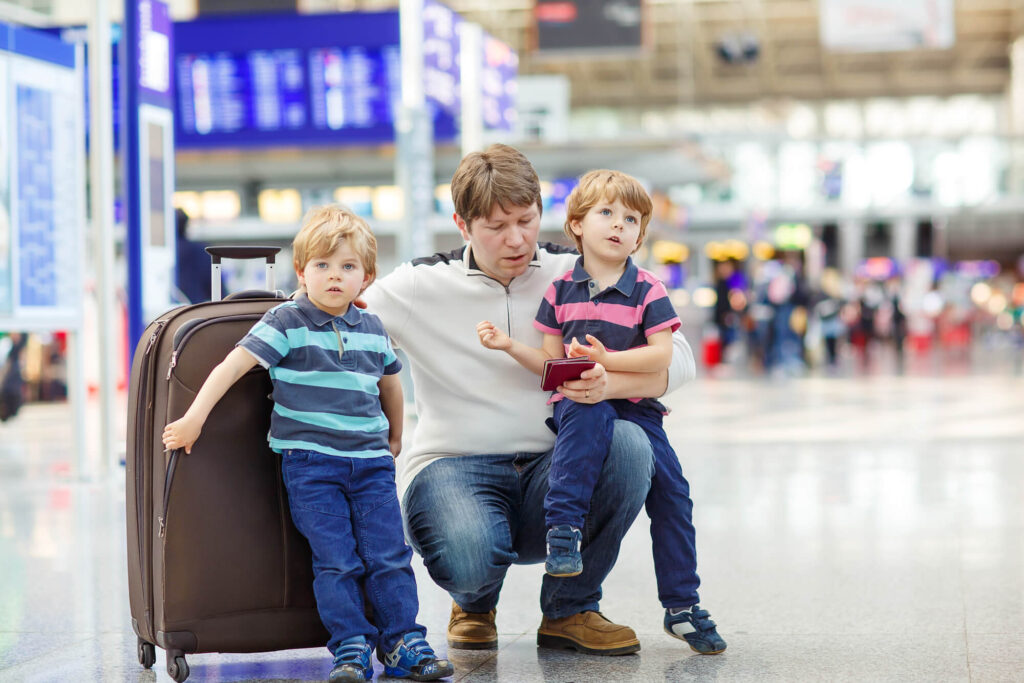 הוצאת הילדים לחופשה בחו"ל | אבא מחבק את 2 ילדיו בשדה תעופה