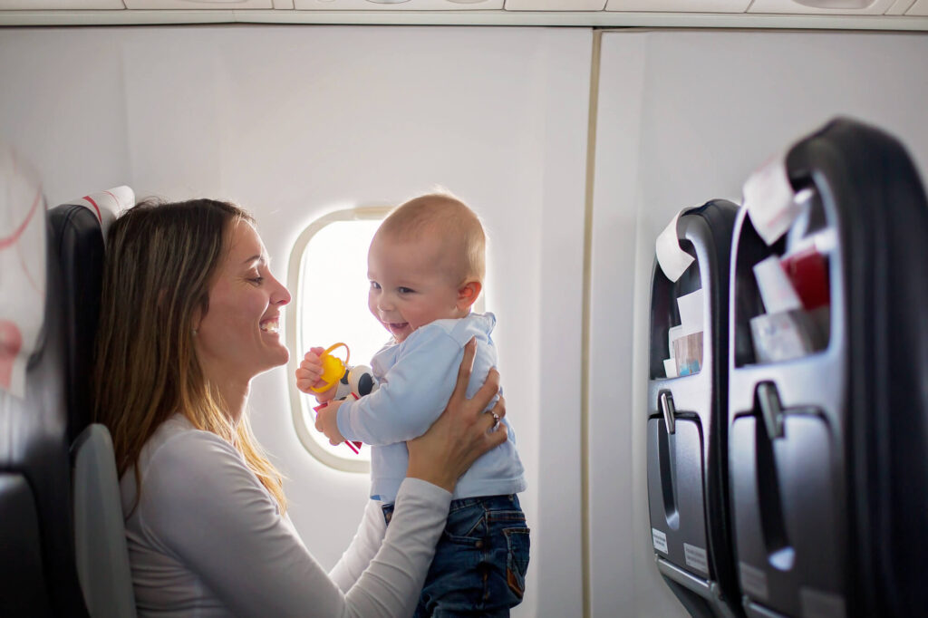 היתר להגירה עם ילדים לחו"ל | אישה עם תינוק במטוס